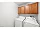 Functional laundry room equipped with a washer, dryer, and overhead cabinets for storage at 1165 Cactus Rock St, Henderson, NV 89011
