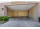 Spacious three car garage with two beige doors, a door to access the home, and exterior lighting at 120 Los Cabos Dr # 301, Las Vegas, NV 89144