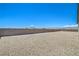 A large gravel backyard is surrounded by a tall block wall in this exterior shot at 1525 Heights Dr, Logandale, NV 89021