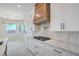 Bright kitchen features white cabinetry, marble countertops, and a modern range hood at 1525 Heights Dr, Logandale, NV 89021