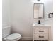 Modern bathroom featuring a white vanity with black hardware, a sleek mirror, and a minimalist design at 1648 J St, Las Vegas, NV 89106