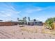 Spacious dirt back yard with gravel and mature trees with covered patio at 21 Laswell St, Henderson, NV 89015