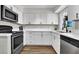 Bright kitchen with white cabinets, stainless steel appliances and wood grain vinyl flooring at 21 Laswell St, Henderson, NV 89015