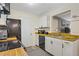 Modern kitchen features white cabinets, wood countertops, and black appliances at 220 Mission Newport Ln # 105, Las Vegas, NV 89107