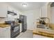 Well-lit kitchen boasts white cabinets, wood countertops, and sleek black appliances at 220 Mission Newport Ln # 105, Las Vegas, NV 89107