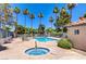 Community pool and spa surrounded by lush landscaping and lounge chairs at 220 Mission Newport Ln # 105, Las Vegas, NV 89107