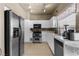 Well-lit kitchen boasting stainless steel appliances, white cabinetry, and tiled countertops at 2500 Cortina Ave, Henderson, NV 89074