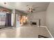 Bright living room showcasing neutral walls, tile flooring, a ceiling fan, and a fireplace at 2500 Cortina Ave, Henderson, NV 89074