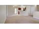 Spacious living room with neutral carpet, leading into the kitchen with dark wood cabinets at 2801 N Rainbow Blvd # 273, Las Vegas, NV 89108