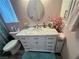Bathroom with white vanity with marble top, oval mirror, and a blue rug at 3031 Pebble Beach Ave, Pahrump, NV 89048