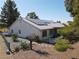 Back exterior view showcasing landscaping, solar panels, and white tiled roof at 3031 Pebble Beach Ave, Pahrump, NV 89048