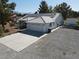Exterior view featuring a two-car garage, solar panels, and ample parking space at 3031 Pebble Beach Ave, Pahrump, NV 89048