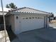 Close up of the two-car garage featuring decorative glass accents, sconce lighting and a long driveway at 3031 Pebble Beach Ave, Pahrump, NV 89048