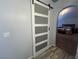 Hallway features a modern barn door, wood floors and access to the primary bedroom at 3031 Pebble Beach Ave, Pahrump, NV 89048