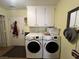 Bright laundry room features a modern washer and dryer, as well as plentiful cabinet space at 3031 Pebble Beach Ave, Pahrump, NV 89048