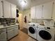 Bright laundry room features a stainless steel sink, washer, dryer, and plenty of cabinet space at 3031 Pebble Beach Ave, Pahrump, NV 89048