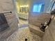 Walk-in shower with bench and modern fixtures viewed from the mosaic tile floor to the double vanity at 3031 Pebble Beach Ave, Pahrump, NV 89048