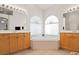 Elegant bathroom with dual vanities, and a luxurious soaking tub set between arched windows at 3088 Evening Mist Ave, Henderson, NV 89052
