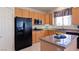 This kitchen has granite countertops, black appliances, and oak cabinets at 3088 Evening Mist Ave, Henderson, NV 89052