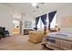 Well-lit main bedroom featuring a comfortable sitting area, carpet floors, and easy access to the Primary bathroom at 3088 Evening Mist Ave, Henderson, NV 89052