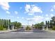 A well-maintained street leads to homes in a gated community enhanced by landscaping and mature trees at 3088 Evening Mist Ave, Henderson, NV 89052