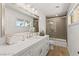 Bright bathroom with a large mirror over a white vanity with marble countertop at 3108 Sonia Dr, Las Vegas, NV 89107