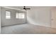 A neutral, carpeted bedroom features two windows and a modern ceiling fan at 3219 Timorasso Ave, Henderson, NV 89044