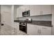 Modern kitchen with stainless steel appliances, granite counters, and white cabinets at 3219 Timorasso Ave, Henderson, NV 89044