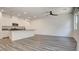 Open-concept living space with modern kitchen, stainless appliances, and wood floors at 3219 Timorasso Ave, Henderson, NV 89044