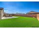 This backyard features artificial grass, concrete patio, and is completely walled in for privacy at 3665 E Garfield Dr, Pahrump, NV 89061