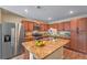Kitchen features stainless steel appliances, granite countertops, wood cabinets, and center island at 3665 E Garfield Dr, Pahrump, NV 89061