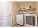 Modern laundry room with front-load washer and dryer, plus overhead shelving at 3665 E Garfield Dr, Pahrump, NV 89061