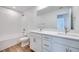 Bathroom featuring double sinks, white cabinets, white subway tile backsplash, and wood-look flooring at 4333 Tabor Peak Ave, Las Vegas, NV 89141