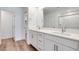 Bathroom featuring double sinks, white cabinets, a large mirror, and a door to the water closet at 4333 Tabor Peak Ave, Las Vegas, NV 89141