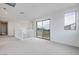Hallway with neutral carpet, white walls, white banister, sliding glass door to patio and a window at 4333 Tabor Peak Ave, Las Vegas, NV 89141