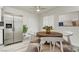 Bright dining area featuring a wood table with white chairs, stainless fridge, and modern decor at 4432 Ash Ave, Las Vegas, NV 89110