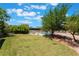 Green backyard featuring a fenced swimming pool, mature trees, and spacious lawn area at 4530 W Shelbourne Ave, Las Vegas, NV 89139