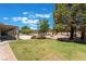 Lush green backyard with mature trees, connected to a covered patio area for outdoor enjoyment at 4530 W Shelbourne Ave, Las Vegas, NV 89139