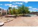 Spacious backyard featuring mature trees, rock landscaping, a pool, and a glimpse of the home's exterior at 4530 W Shelbourne Ave, Las Vegas, NV 89139