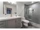 Modern bathroom featuring a gray vanity, toilet, and shower with glass door and gray tiling at 4530 W Shelbourne Ave, Las Vegas, NV 89139