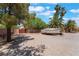 Large, gravel lot with space for RV or boat parking behind a fence and mature trees at 4530 W Shelbourne Ave, Las Vegas, NV 89139