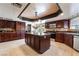 Beautiful kitchen featuring dark wood cabinets, stainless steel appliances, and a center island with stone countertops at 4530 W Shelbourne Ave, Las Vegas, NV 89139