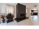 Modern living room featuring a dark fireplace, tile flooring, and a glimpse of the kitchen at 4530 W Shelbourne Ave, Las Vegas, NV 89139