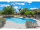 Backyard pool with a tanning shelf, lush landscaping, and covered patio in the distance at 4530 W Shelbourne Ave, Las Vegas, NV 89139