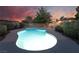 Inviting pool with cool blue water and safety fence, set against a colorful sunset sky at 4530 W Shelbourne Ave, Las Vegas, NV 89139