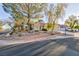 Charming single-story home featuring a landscaped front yard with mature trees and a two-car garage at 5601 Cavalier Cir, Las Vegas, NV 89130