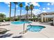 Community pool area with hot tub, surrounded by lush palm trees and lounge chairs at 7241 Indian Creek Ln # 203, Las Vegas, NV 89149