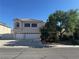 Two-story home with a three car garage, red tile roof, and lush landscaping in a sunny neighborhood at 7416 Alcove Glen Ct, Las Vegas, NV 89129