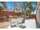 Relaxing backyard patio area with a table, chairs, grill, and mature landscaping at 7437 Treasure Chest St, Las Vegas, NV 89139