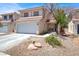 Two-story home featuring a red tile roof, two-car garage, and desert landscaping at 7437 Treasure Chest St, Las Vegas, NV 89139